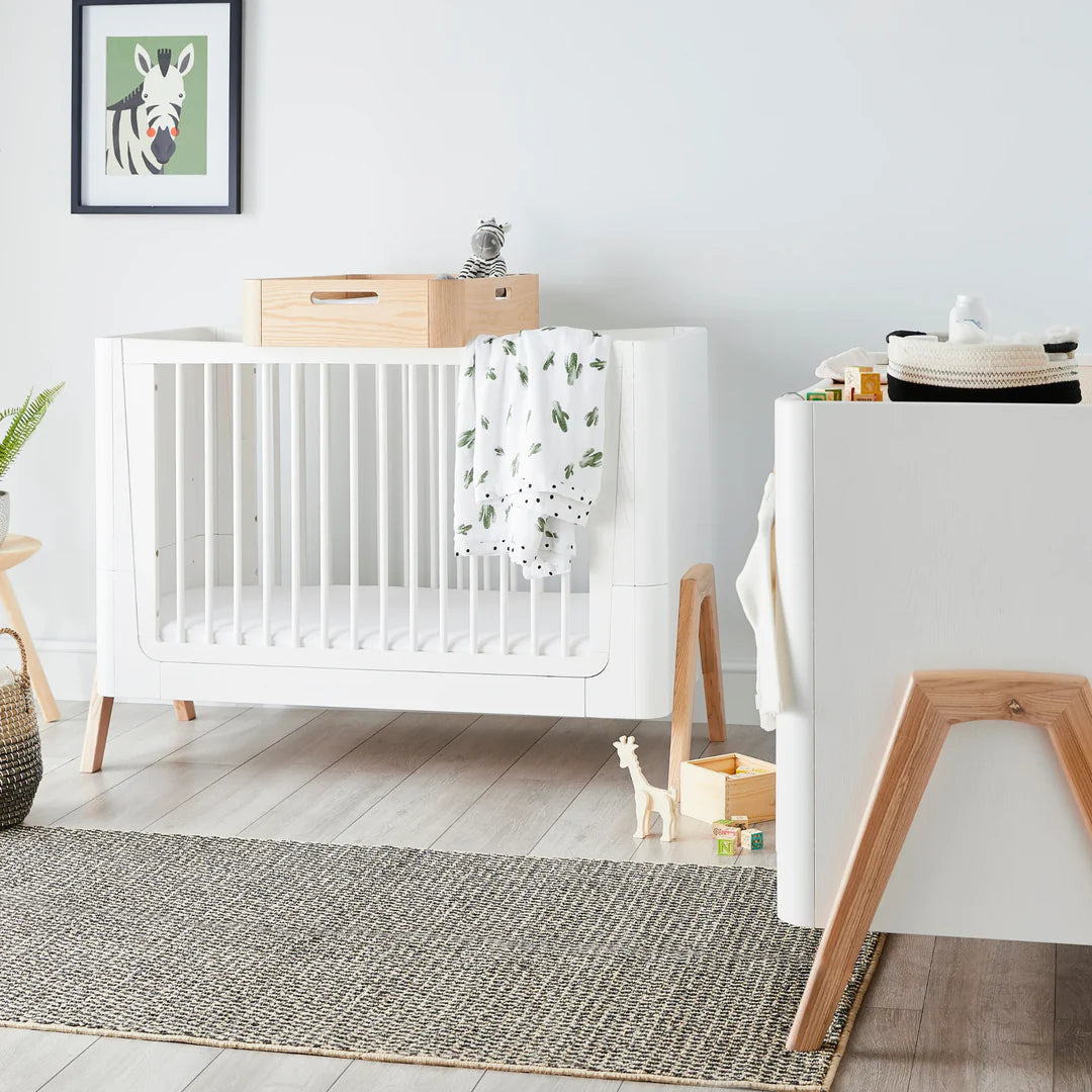 A Gaia Baby nursery with a matching cot bed, dresser and changing station