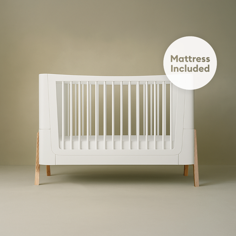 Gaia Baby Hera Cot Bed in Scandi White with natural finish, featuring a sturdy frame and an included mattress for a cozy nursery.