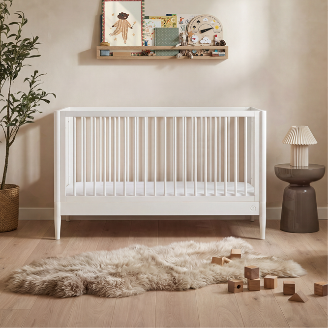 White Gaia Baby Eos cot bed with sturdy wooden frame and slatted sides, suitable for nursery sleep and baby’s comfort.