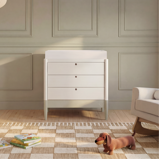 White Gaia Baby Eos Dresser with sleek modern design and multiple drawers, featuring a desert sage accent finish.