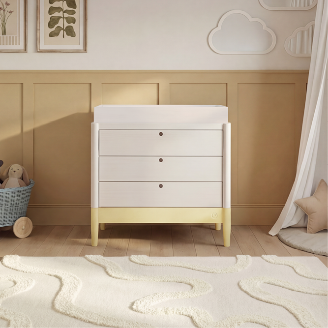White Gaia Baby Eos dresser with saffron yellow accents, featuring multiple drawers and modern design for nursery storage.