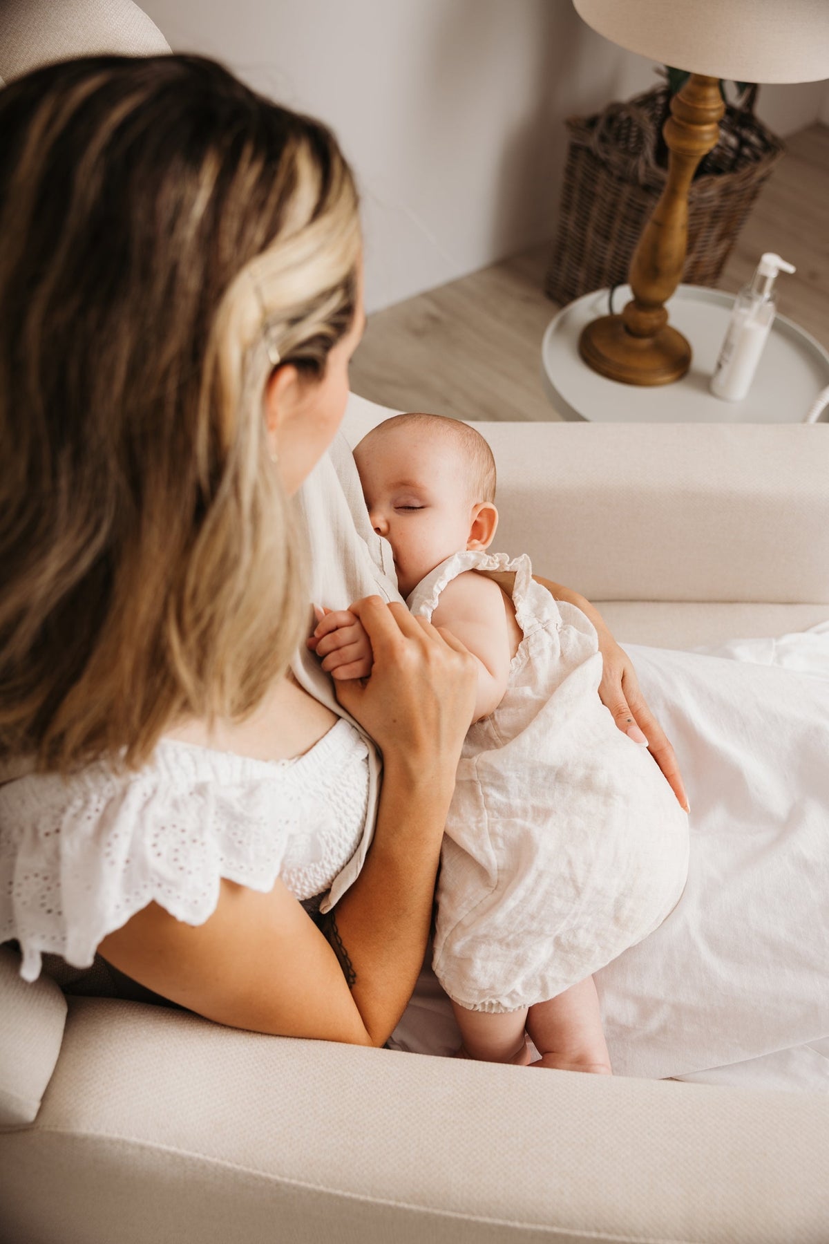 Mother feeding her baby in the Lyra nursing chair in Oat, seen from above