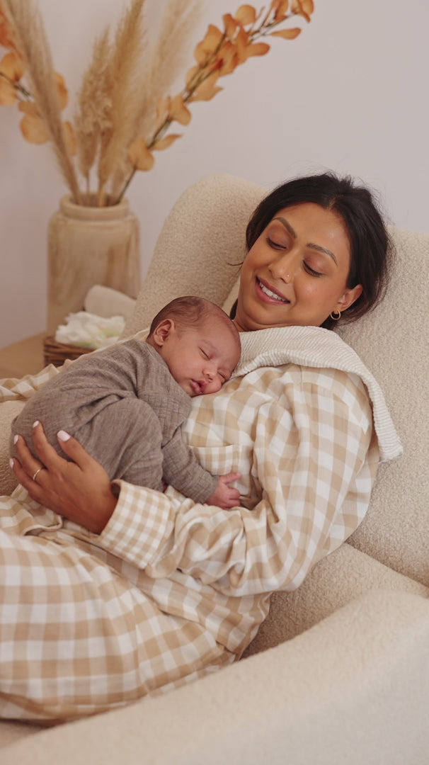 Close up of a mother with her sleeping newborn in the Lyra nursing chair in Biscuit Bouclé